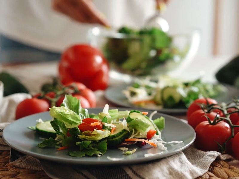 prikaz salata na tanjiru i na stolu u pozadini, zelena, paradajz, krastavac..