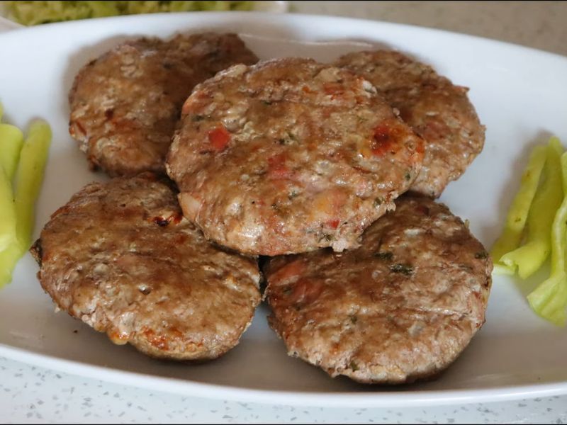 servirane pljeskavice iz rerne na belom tanjiru uz ljute papričice